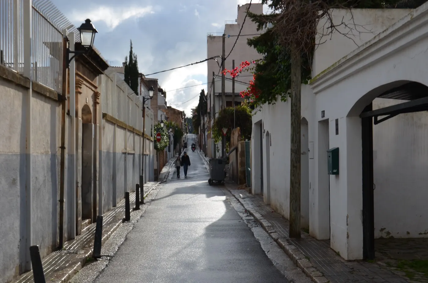 Ansteigende Gasse in El Terreno mit weißen Häusern, grünen Toren und Laternen