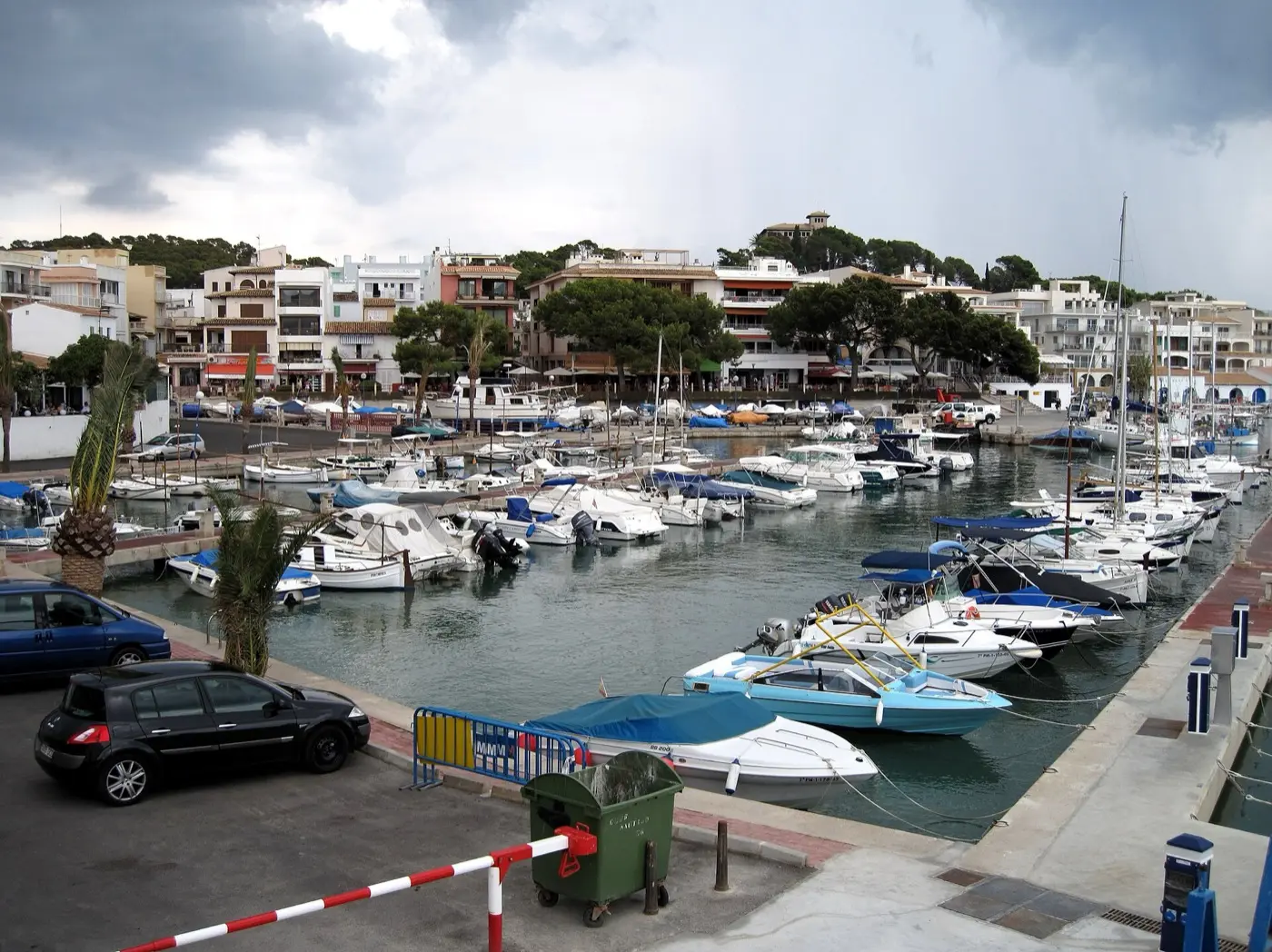 Hafen von Cala Rajada mit Booten am Kai und Häusern am Ufer