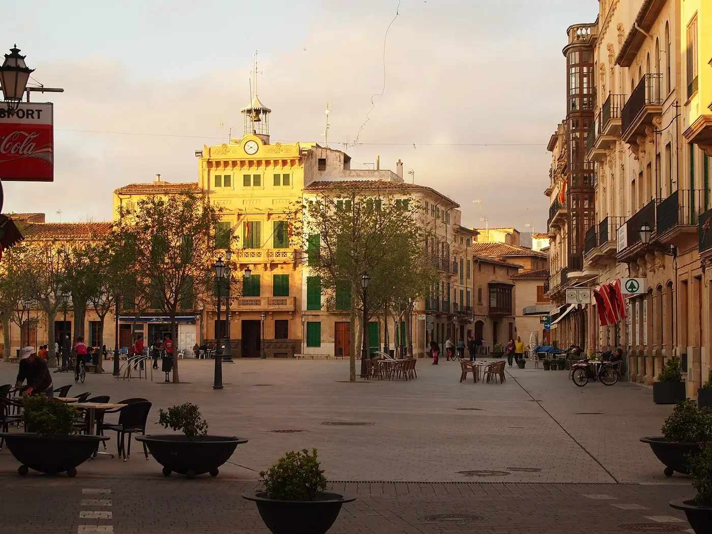 Plaça d’Espanya in Llucmajor mit dem Rathaus in der Mitte, Bäumen und Tischen auf dem Platz