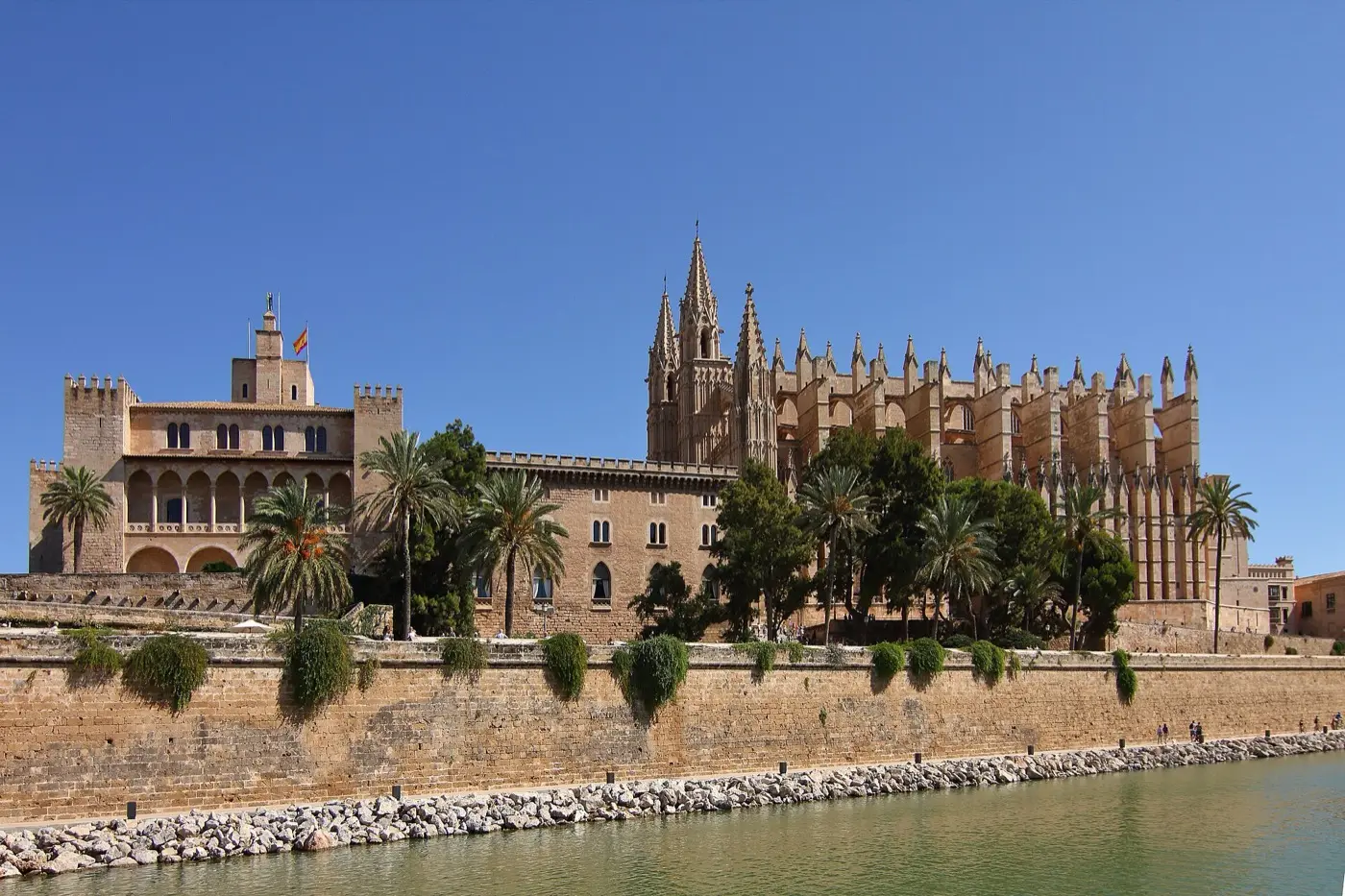 Kathedrale La Seu und Palau de l’Almudaina über der Stadtmauer, davor das Wasser im Parc de la Mar