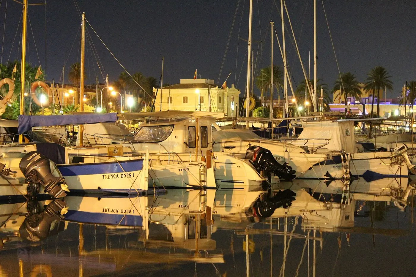 Boote im kleinen Hafen von Portixol am Abend mit Lichtern am Ufer